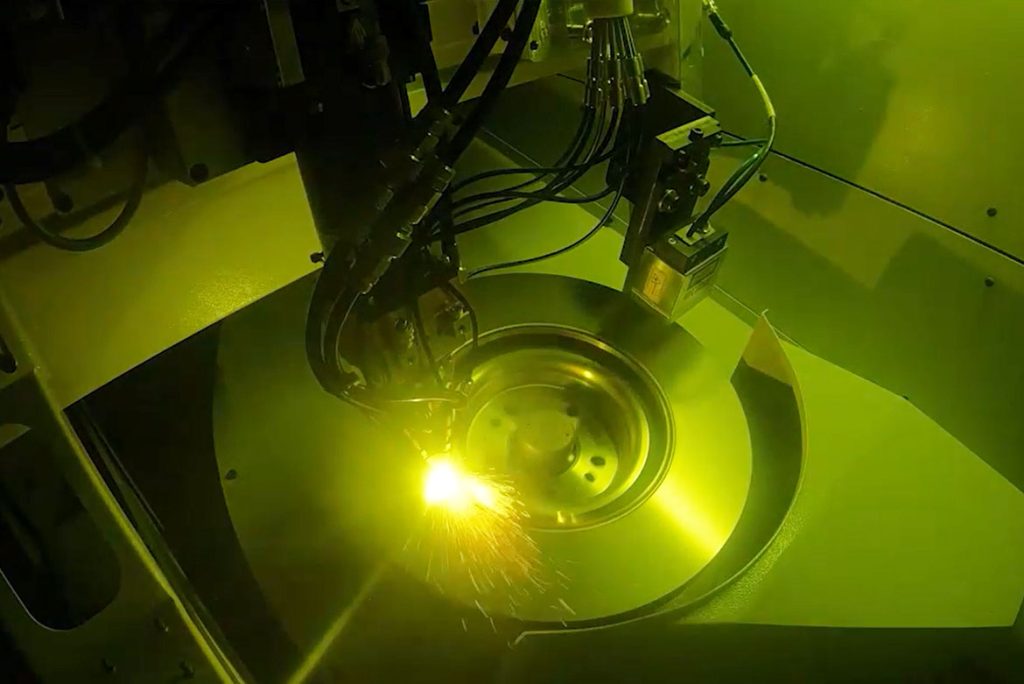 Laser coating process, ELC 450 DUO LMD, on a rotating brake disk with visible arc and sparks - use of LMD technology.