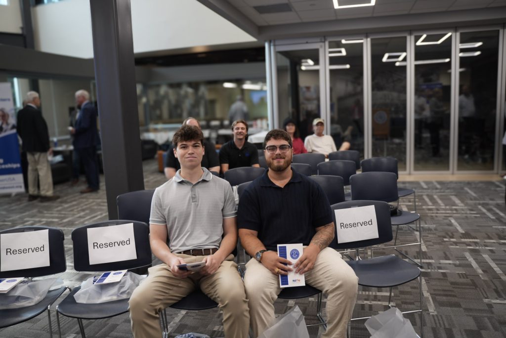 Levi Rittinger and Nil Skrzypczak sit together during the EMAG MAT² Apprenticeship Program graduation ceremony.