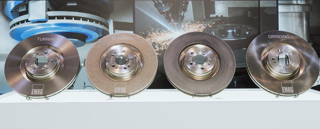 La imagen muestra cuatro discos de freno en diferentes estados de fabricación: después del torneado, después del recubrimiento láser de la capa adhesiva, después del recubrimiento láser de la capa de fricción y después del rectificado.