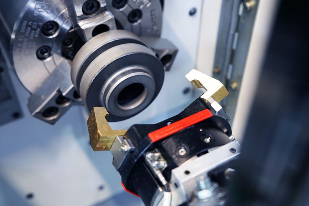 Pinza doble del MSC 5 DUO durante la colocación automática de una pieza de trabajo en el mandril del husillo del torno CNC.