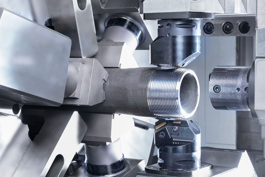 Detailaufnahme des Arbeitsraums der USC 21 Maschine mit zwei Werkzeugrevolvern, die simultan Rohre bearbeiten.