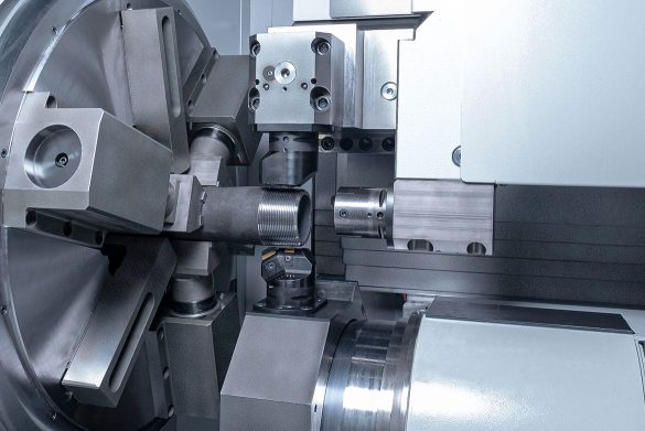 EMAG USC 21 – effiziente simultane Bearbeitung mit zwei Revolvern Nahaufnahme des Arbeitsraums einer EMAG USC 21: Zwei Werkzeugrevolver (oben und unten positioniert) bearbeiten gleichzeitig ein Rohrende.
