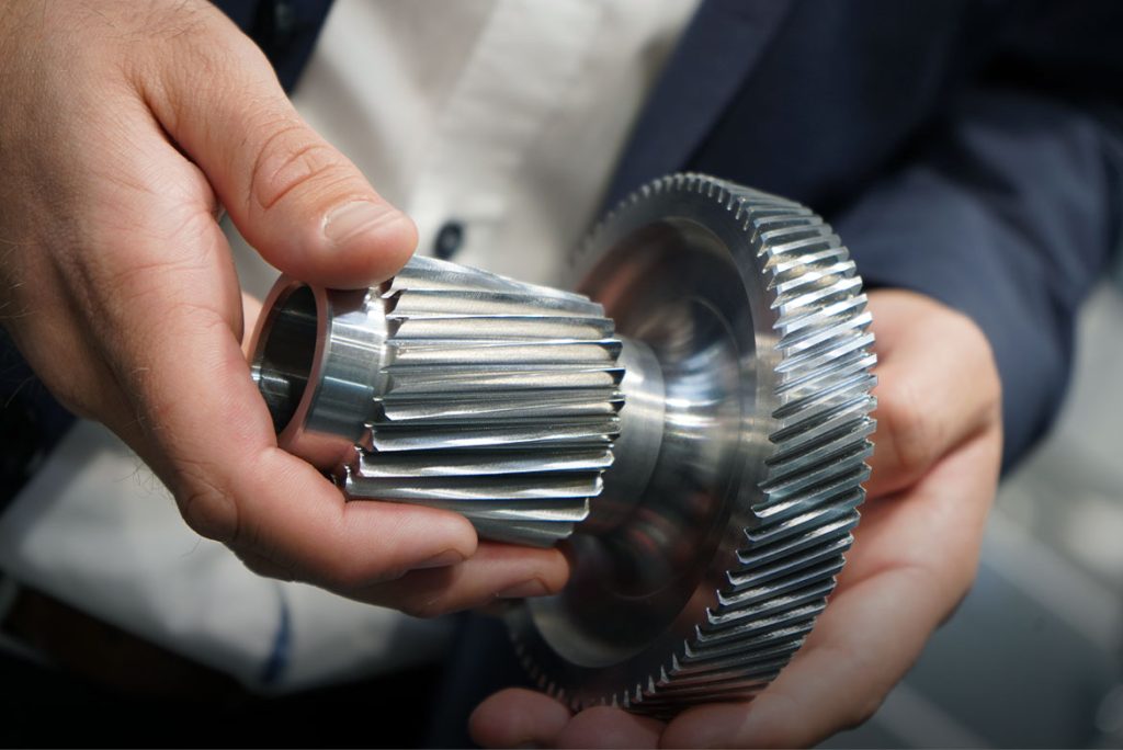 Stufenplanet mit Innenverzahnung und Außenverzahnung für E-Antrieb-Getriebe in Händen gehalten, zeigt die zweistufige Geometrie.